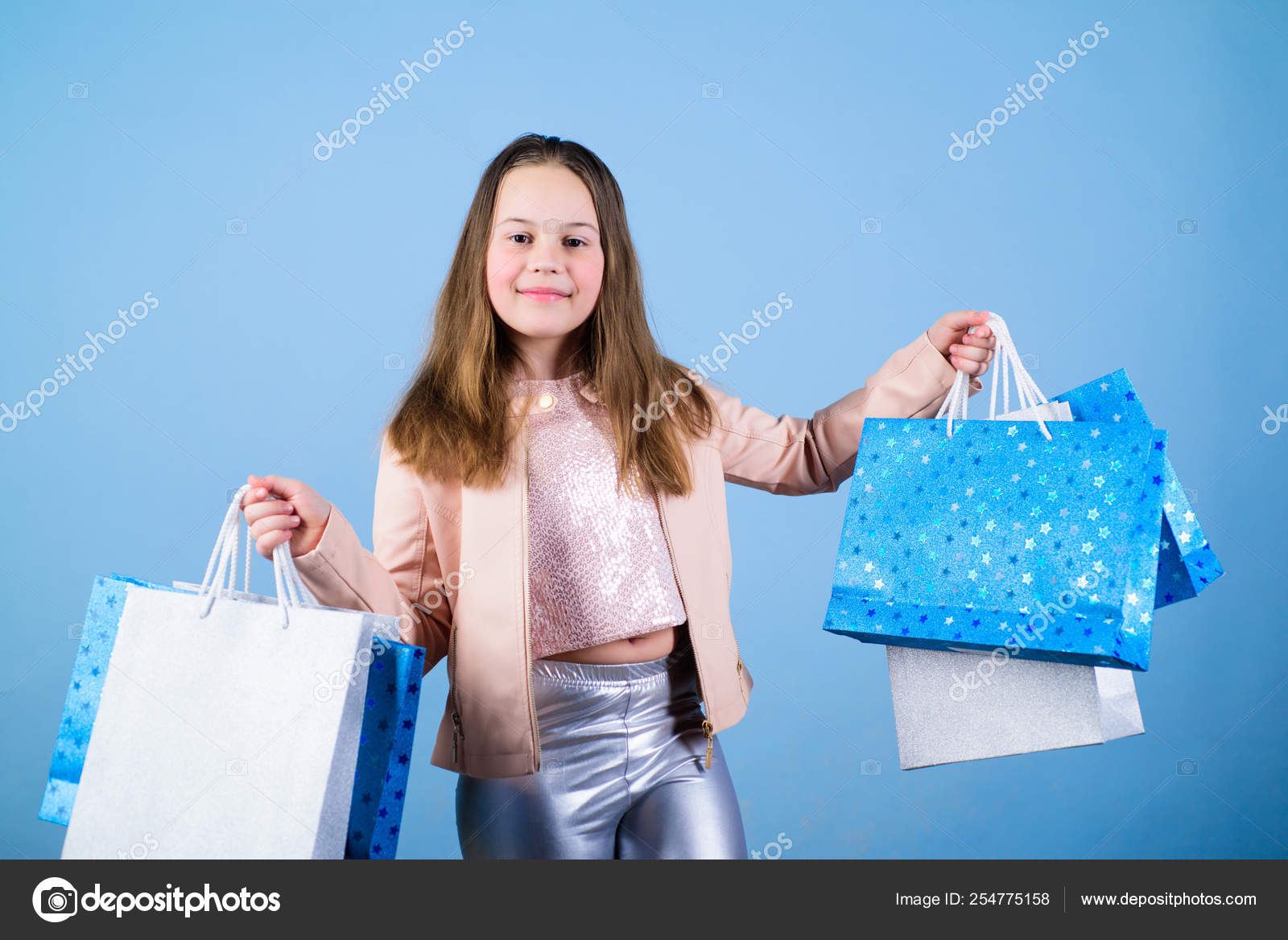 Niña con paquetes. Cliente chica de moda. Niño feliz en la tienda con bolsas.  Día de