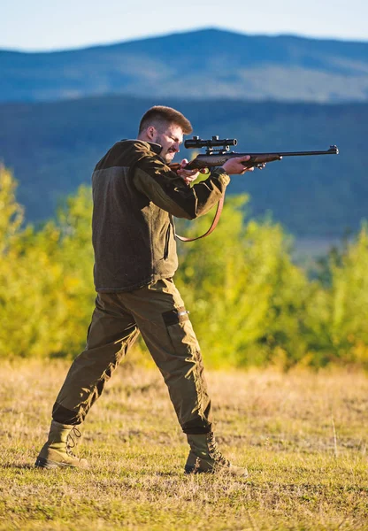 Muž puška pro lov. Hunter khaki šaty lovit držet zbraň hory pozadí. Hunter s puškou hledá zvíře. Lovecké střelby trofej. Mentální příprava pro lov individuální proces — Stock fotografie