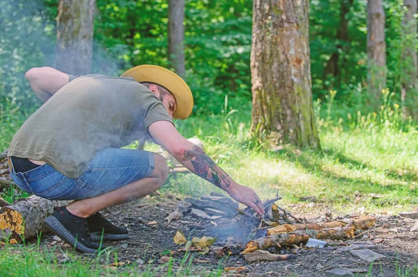 Guide ultime pour les feux de joie. Disposer les brindilles de bois ou les bâtons de bois debout comme une pyramide et placer les feuilles sous. Chapeau de paille homme prépare feu de joie dans la forêt. Comment construire un feu de joie à l'extérieur — Photo