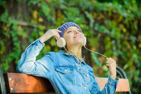 Relajarse en el parque. chica hipster relajarse en el parque con reproductor de mp3. mujer hipster en auriculares relajarse en el parque. escuchar música al aire libre. libro de audio. estilo y música. tecnología moderna en lugar de leer — Foto de Stock