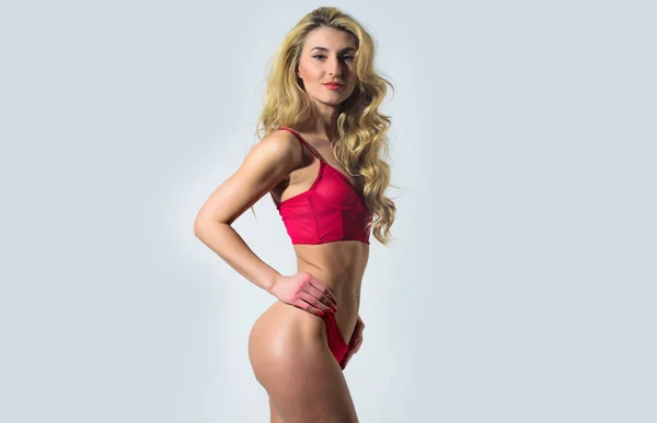 Erotische verleiding. Sexy vrouw met lang krullend haar. Haar schoonheid van sensuele meisje. Perfecte lichaamsvorm. Sexy blonde vrouw. Erotische lingerie en ondergoed. Mannequin met fit buik. Erotische fantasie — Stockfoto