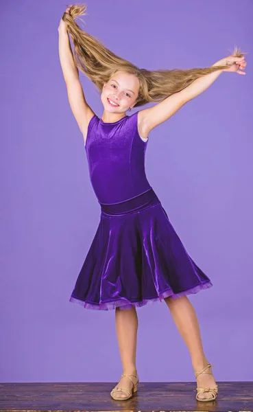Hairstyle for dancer. How to make tidy hairstyle for kid. Things you need know about ballroom dance hairstyle. Ballroom latin dance hairstyles. Kid girl with long hair wear dress on violet background