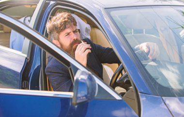 Adam işadamı süre arabada oturup sigara içilmeyen sakallı. Sürücü duman sigara. Dakika dinlenmek için. İşadamı araç sigara zor görüşmelerin ardından yorgun. Özel araçlarda sigara yasakları