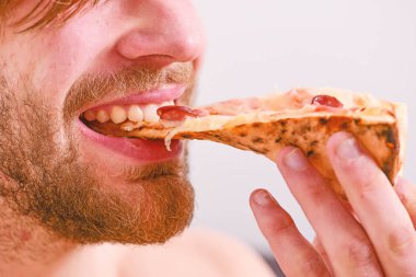 İç çamaşırı aç genç adam evde pizza kutusu ile bir yatakta oturur. Ara diyet kavramı. Gıda teslim Servisi. Evde pizza.
