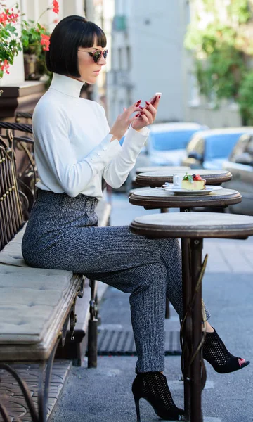 Koppla av och fika. Ring vän. Fritid-konceptet. Flicka moderiktiga dam med smartphone. Kvinna attraktiv elegant brunett tillbringar fritid café terrass bakgrund. Trevlig tid och fritid — Stockfoto