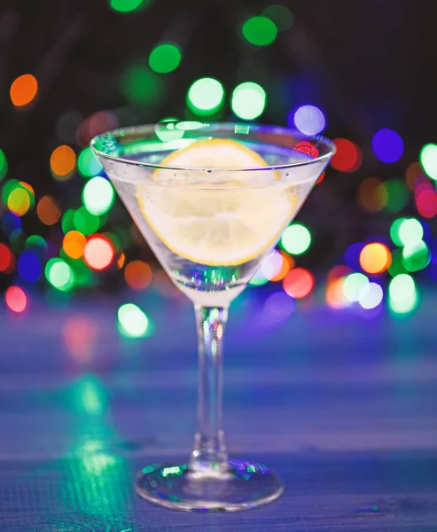 Ne içecek Noel partisi. Kokteyl cam su ve dilim limon defocused çelenk ışık ile. Daha iyi hissetmek için içki detoks. Akşamdan kalma ve detoks. Kış partiden sonra detoks. Sağlık kavramı — Stok fotoğraf