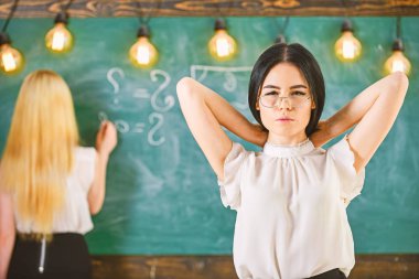 Çekici bir kadın ders için hazırlanıyor. Öğrenci ve kursiyer kavramı. Öğrenci, Öğretmen sınıfta gözlük standında. Kız çekici Bayan defocused kara tahta arka plan üzerinde yazma sırasında görünüyor