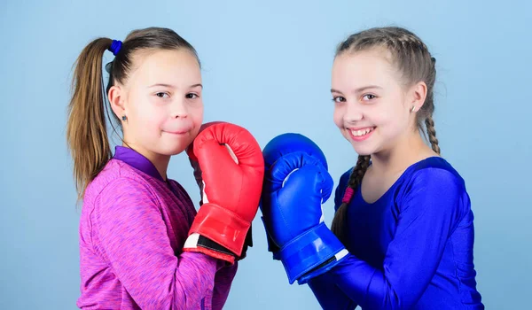 Φιλία ως μάχη και τον ανταγωνισμό. Περάσει πρόκληση πυγμαχία. Τεστ για την καρτερία. Γυναικεία φιλία. Κορίτσια στο άθλημα της πυγμαχίας. Μπόξερ παιδιών σε γάντια του μποξ. Κορίτσια χαριτωμένα μπόξερ σε μπλε φόντο — Φωτογραφία Αρχείου