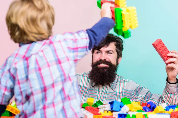 Cuidado de niños y crianza. Padre hijo juego. Padre hijo crear construcciones. Padre y niño ocio familiar. Padre líder mostrando chico cómo crecer en el hombre exitoso. Papá y el niño construyen bloques de plástico —  Fotos de Stock