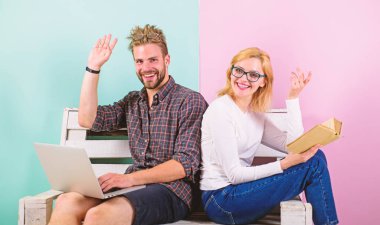 Kız koca freelancer laptop ile çalışırken hayatını tadını çıkarın. Yüz kitap çalışan erkeğin yakınındaki okuma gülümseyen kadın. Adam serbest üzerinde Internet teknolojileri uzmanı çalışıyor. Serbest faydaları