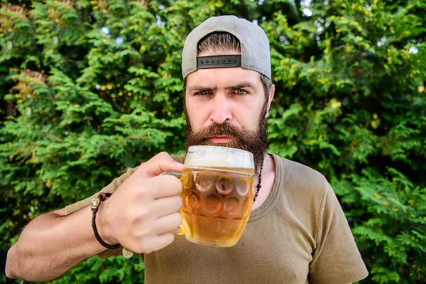 His drinking choice. Hipster drinker. Hipster holding beer mug. Bearded hipster drinking beer on nature. Hipster man with craft beer. Brutal man with drinking habits. Drinking only the best beer