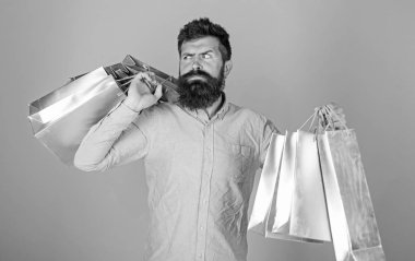 Satış ve indirim kavramı. Satış sezon indirimlerle alışveriş adam. Katı yüz bağımlısı alışveriş veya Alışverişkoliğin hippi. Sakal ve bıyık taşımak alışveriş torbaları, açık mavi renkli olan adam