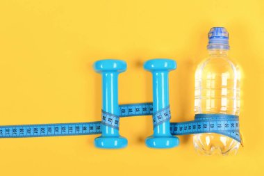 Şişenin ve dambılın etrafına sarılmış santimetre, üst manzara..