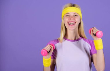 Kadınlar için üst vücut egzersizi. Dambıl tutan kızlar parlak bileklikler takarlar. Klasik spor konsepti. Dambıllarla egzersiz yapan bir kadın. Dambıllarla kolay egzersizler. Dambıllarla egzersiz.