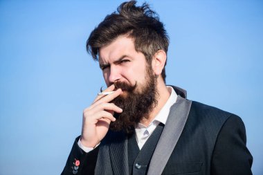 Sigara içmek için mola. Sakallı adam sigara içiyorum. duman. Bıyıklı acımasız beyaz hippi. Gelecekteki başarısı. Erkek resmi moda. İş adamı gökyüzüne karşı. Olgun hipster sakallı