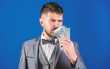 Zenginlik ve refah kavramı. Nakit para kolay ve hızlı bir şekilde almak. Para gibi kokuyor. Kolay nakit krediler. Resmi takım elbise mavi arka plan doları banknot yığını tutun. İşadamı nakit para var.