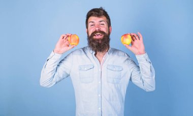 Sağlıklı bir alternatif. Sakallı adam gülen elma mavi arka plan elinde tutar. Elma hem de sağlıklı alternatif eller. Tamamen sağlıklı beslenme kavramı. Vitamini beslenme diyet sağlık