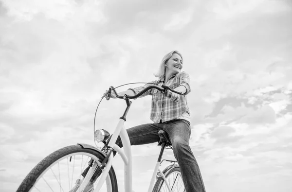 Mädchen fährt Fahrrad Himmel Hintergrund. befriedigendste Form des Selbsttransports. Unbekümmert und zufrieden. Frau fühlt sich frei und genießt Radfahren. Radfahren gibt Ihnen ein Gefühl von Freiheit und Unabhängigkeit — Stockfoto