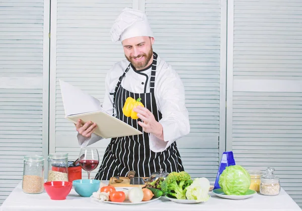 Guy läsa bok recept. Måltidskunskap koncept. Man lära dig recept. Förbättra matlagning skicklighet. Ultimata matlagning guide för nybörjare. Boka familjerecept. Enligt receptet. Man bearded kock Matlagning mat — Stockfoto