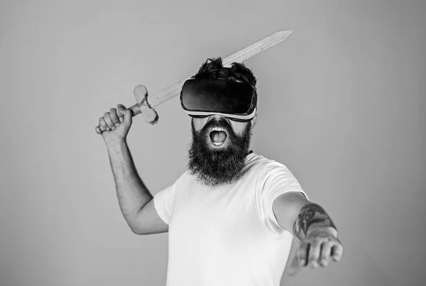 Hipster auf schreiendem Gesicht genießen das Spiel in virtueller Realität. vr gamer concept. Kerl mit Kopf montiert Display und Schwert spielen Kampfspiel in vr. Mann mit Bart in vr Brille, hellblauer Hintergrund — Stockfoto