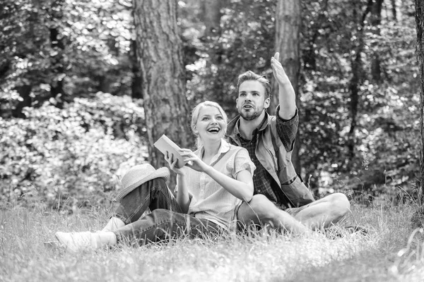 Romantic couple students enjoy leisure looking upwards observing nature background. Couple in love spend leisure in park or forest. Romantic date at green meadow. Couple soulmates at romantic date