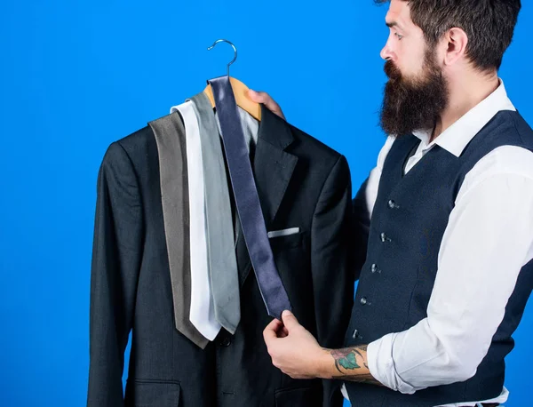 Compras de roupas de negócios. Comprador barbudo combinando gravata para casaco em shopping center. Hipster compras a mais recente coleção de gravata. Assistente de loja oferecendo ampla variedade de gravatas para fazer compras — Fotografia de Stock