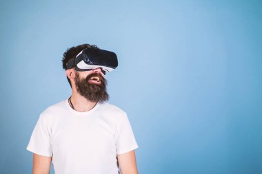 Gülümseyen yüzü üzerinde yenilikçi gadget ile sanal gerçeklik tadını çıkarın. Vr gözlük, açık mavi renkli sakallı adam. Dijital teknoloji kavramı. Adam kafa monte ekran ile etkileşim içinde sanal gerçeklik