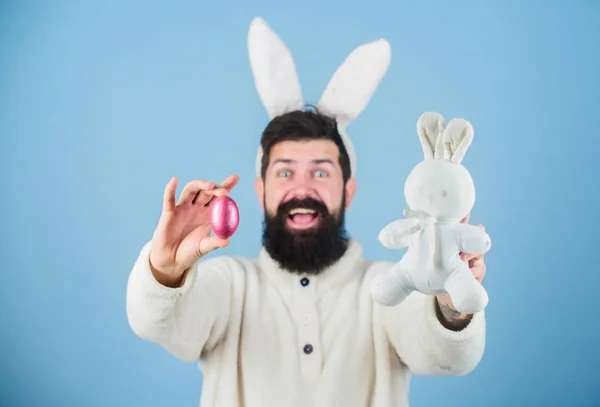 Багатий подарунок, щоб поділитися. Пасхальний кролик доставляє кольорові яйця. Гіпстер з довгими вухами кролика, що тримають заєць для відкладання яєць. Бородатий чоловік з іграшкою кролика та пасхальним яйцем. Святкування весняних свят — стокове фото