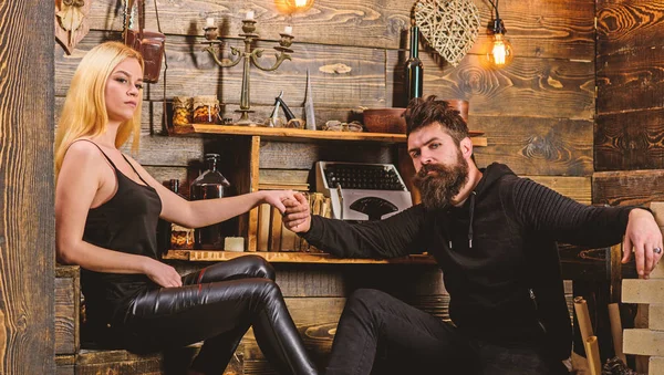 Çift gamekeepers evde, ahşap iç arka plan romantik akşamın. Aşık çift birlikte ellerini tutar. Romantik akşam kavramı. Kız ve erkek rahat yüzleri sıcak atmosferinin keyfini çıkarın