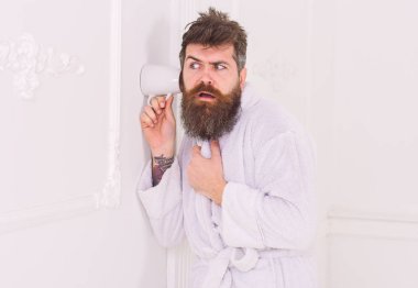 Casusluk, gizli dinleme beyaz iç adam. Gizli ve casus kavramı. Adam sakal ve bıyık kupa duvarının yakınında kullanarak eavesdrops. Hipster katı yüz bornoz içinde gizlice konuşma dinle