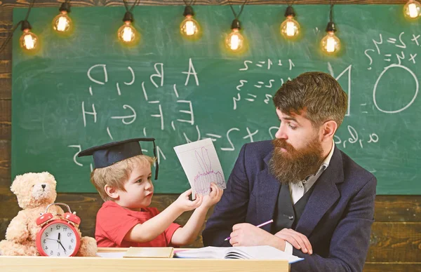 先生は、鏝板、背景に黒板の生徒。父は息子を教えて基礎知識について、説明します。初等教育のコンセプトです。先生、注意する聞くと子供研究 — ストック写真