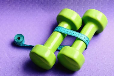 Cyan cetvelinin yanında küçük boy halterler.