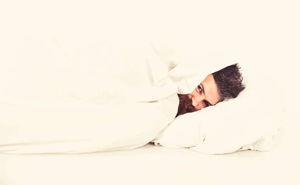 Guy with beard hides face under blanket. Lazy and laziness — Stock Photo, Image
