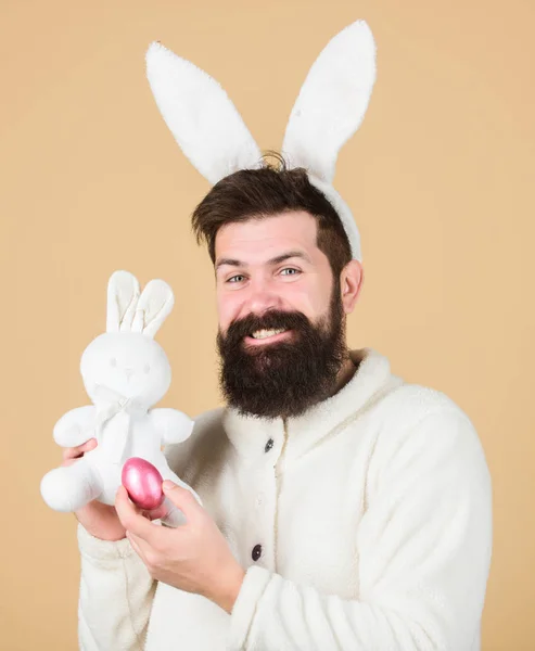 Funny Bunny man zachte oren. Man draagt konijn pak spelen met speelgoed. PaaS activiteiten concept. Nog kinderachtig. Vier Pasen. Guy baard hipster vrolijke Bunny met lange witte oren. Paashaas — Stockfoto