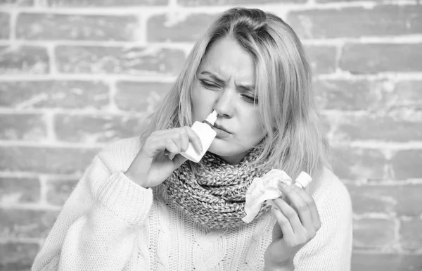 Having nasal stuffiness. Pretty girl with runny nose holding nasal drops. Sick woman injecting drops into nose. Cute woman nursing nasal cold or allergy. Suffering from asthma or allergic rhinitis — Stock Photo, Image
