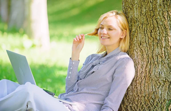 Girl work with laptop in park sit on grass. Education technology and internet concept. Natural environment office. Work outdoors benefits. Woman with laptop work outdoors lean tree. Minute for relax