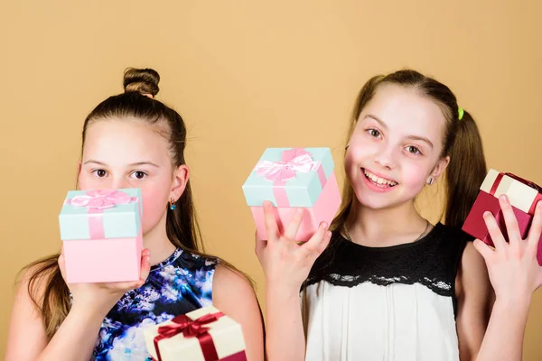 Feliz día. Niños niñas encantado regalo. Las chicas adorables celebran cumpleaños. A los niños les encantan los regalos. Compras y vacaciones. Las hermanas disfrutan los regalos. Los niños sostienen cajas de regalo fondo beige —  Fotos de Stock