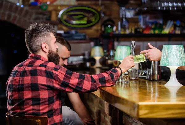 Män som kopplar av i baren. Vänskap och fritid. Fredags avkoppling i baren. Vänner koppla av i puben. Beställ drinkar vid bar disken. Hipster brutal skäggiga man tillbringar fritid med vän på bar Counter — Stockfoto