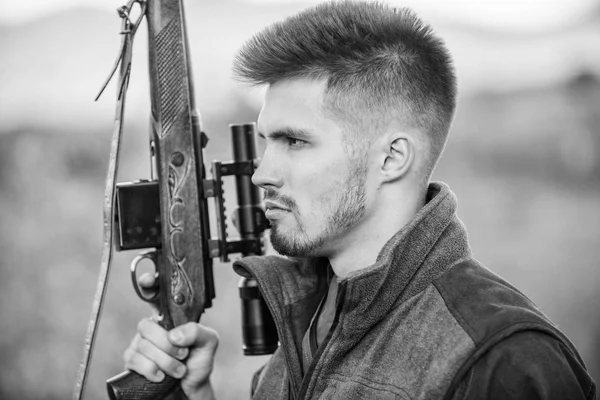 Caçando conceito de hobby masculino. Homem brutal gamekeeper natureza fundo. Regulação da caça. Hunter segura na espingarda. Caçador barbudo passa a caça ao lazer. Foco e concentração de caçadores experientes — Fotografia de Stock