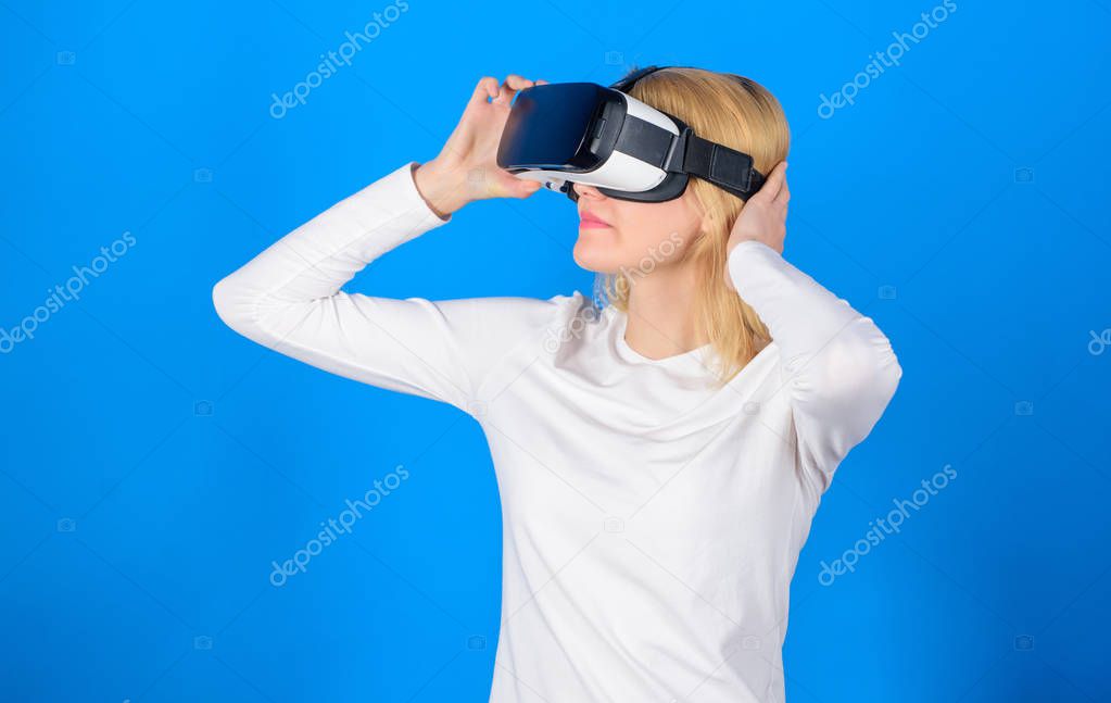 Happy young woman wearing virtual reality goggles watching movies or playing video games. Excited smiling businesswoman wearing virtual reality glasses. Woman enjoying cyber fun experience in vr.