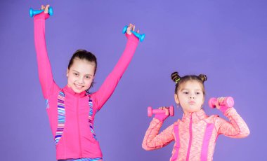 Kız kardeşinin peşinden yürümeye başlayan tekrar egzersiz. Çocuklar için spor egzersizleri. Sağlıklı bir yetiştirme. Sportif bebekler. Kız kardeşini takip ediyorum. Kızlar Sevimli çocuk dumbbells ile egzersiz. Motivasyon ve spor örneği konsepti