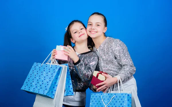 Friendship. Kid fashion. shop assistant with package. Sisterhood. Holiday purchases. Small girls with shopping bags. Sales and discounts. Happy children. Little girl sisters with gift box, friendship. — Stock Photo, Image