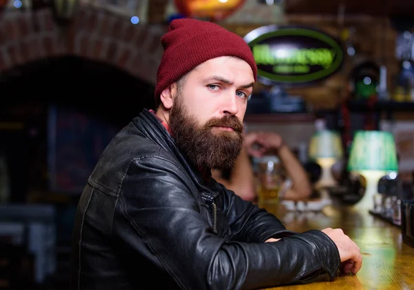 De mens met baard besteedt vrije tijd in donkere bar. Brutale eenzame hipster. Brutale hipster baard man zitten op Bar Counter. Vrijdagavond. Hipster ontspannen in bar. Bar is ontspannen plek om te drinken en te ontspannen — Stockfoto