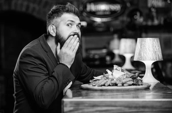 Man received meal with fried potato fish sticks meat. Delicious meal. Enjoy meal. High calorie snack. Cheat meal concept. Hipster hungry eat pub fried food. Manager formal suit sit at bar counter