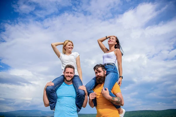 La diversión acaba de empezar. Parejas juguetonas enamoradas sonriendo en el cielo nublado. Hombres felices apoyando a sus novias. Amar a las parejas que tienen actividades divertidas al aire libre. Parejas amantes disfrutan de la diversión juntos —  Fotos de Stock