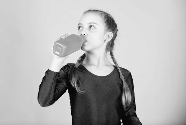 Ontspannen na de training van de gymnastiek van tiener meisje. Rusttijden. Jeugd activiteit. Sport en gezondheid. Kleine meisje drinkwater uit de fles. Gelukkig kind sportman. Fitness en dieet. Energie. Ontspannen na de training — Stockfoto