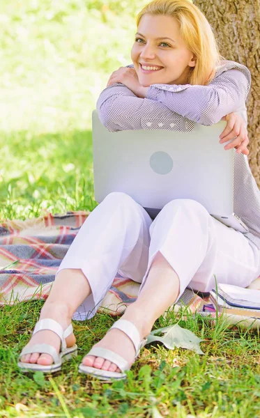 Girl work with laptop in park sit on grass. Natural environment office. Woman with laptop work outdoors lean tree. Minute for relax. Education technology and internet concept. Work outdoors benefits