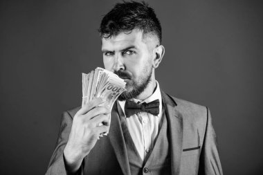 İşadamı nakit para var. Zenginlik ve refah kavramı. Nakit para kolay ve hızlı bir şekilde almak. Para gibi kokuyor. Kolay nakit krediler. Resmi takım elbise tutun doları banknot yığını mavi arka plan