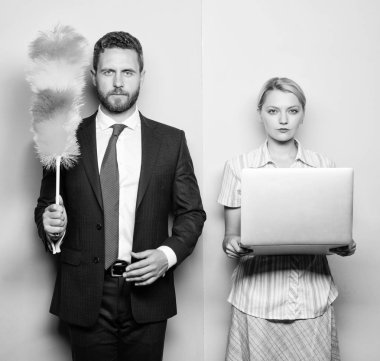 Househusband ve kadın patron. İşadamı ve ev kadını. Aile çift. Dizüstü holding eş sırasında toz fırçası ile kocası stand. İki yakışıklı ve güzel bir kadın. Ev veya iş