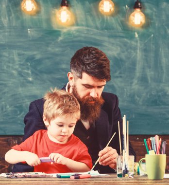Baba oğlu boyamak eğitmektir. Şirin çocuk babası boyama izlerken